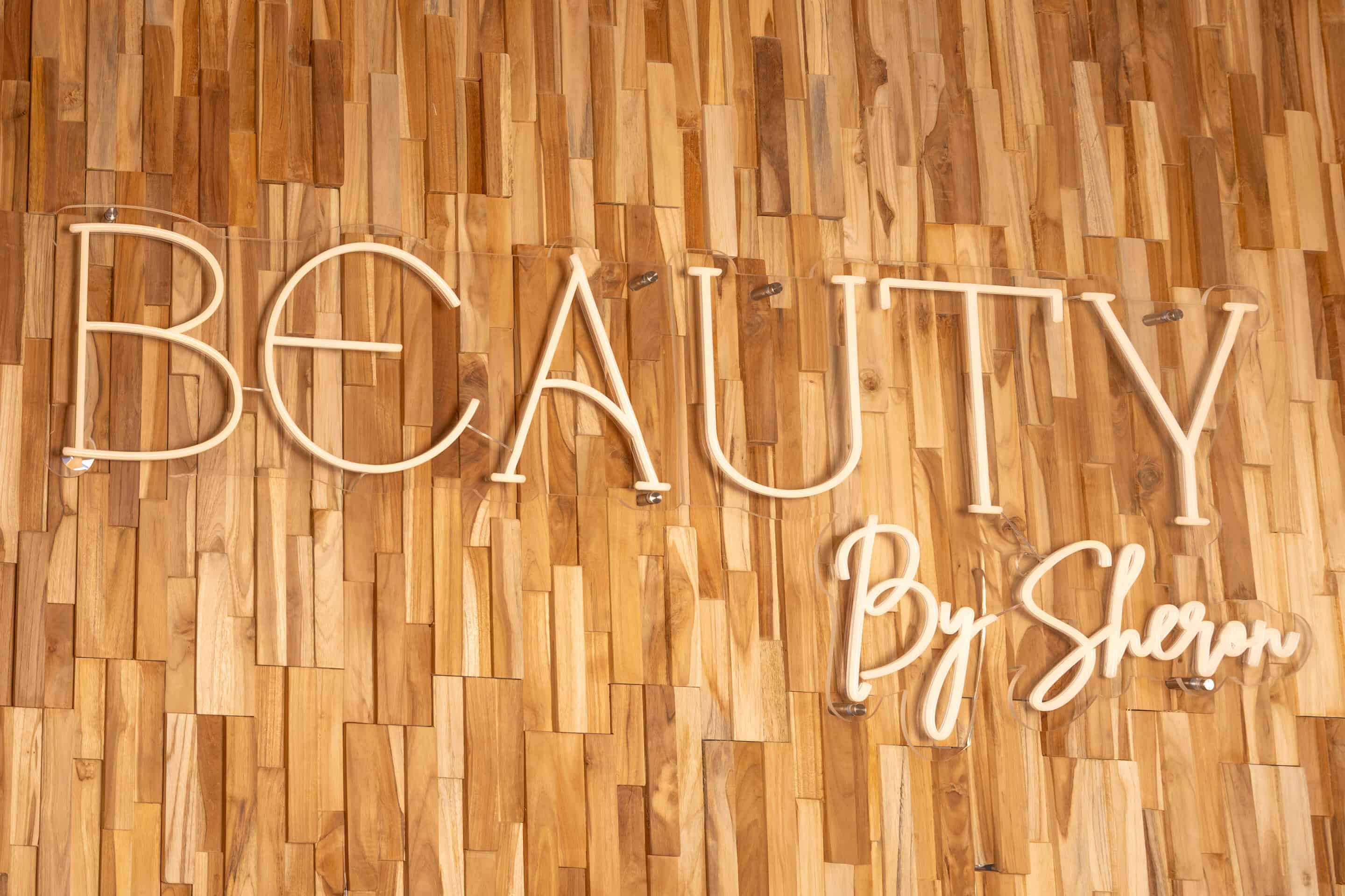 De letters Beauty by Sheron op de houten wand in de salon